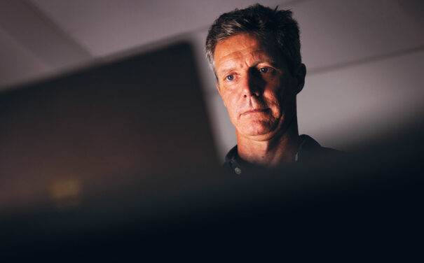 Dr Ian Norton sitting at laptop